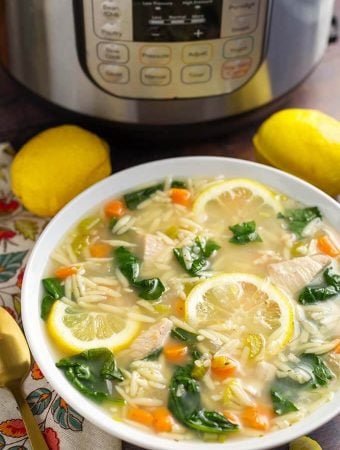 Lemon Chicken Orzo Soup in a white bowl in front of a pressure cooker is a light and delicious soup that you can make in minutes. This pressure cooker lemon chicken orzo soup is a healthy and simple Instant Pot chicken soup. simplyhappyfoodie.com #instantpotchickensoup #instantpotsoup #pressurecookerchickensoup