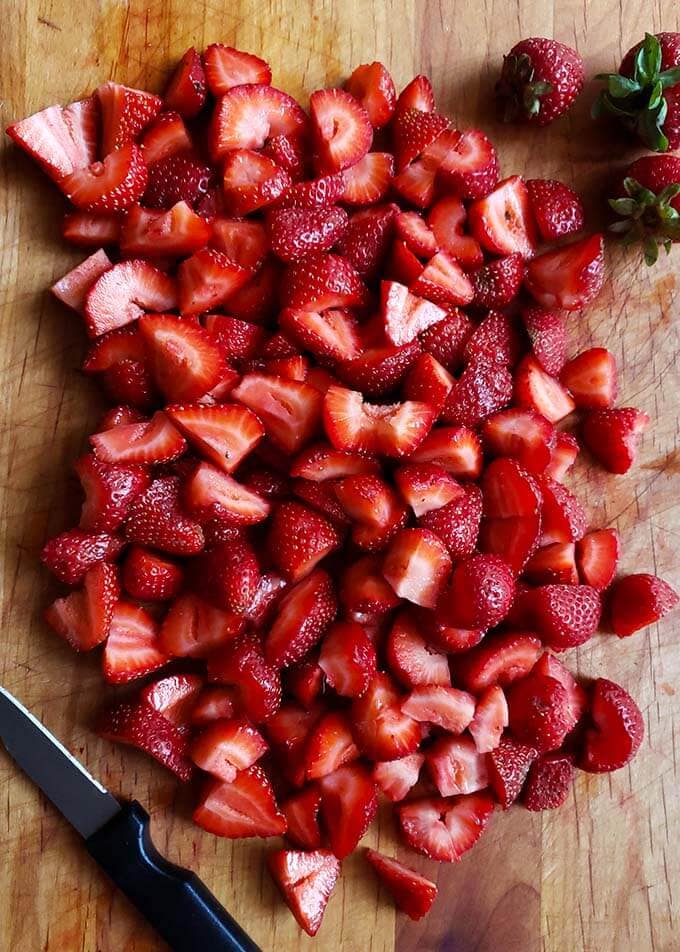 chopped strawberries on a wooden board