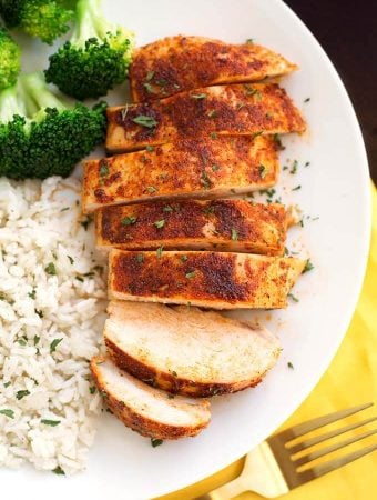 Sliced Baked Chicken Breast on a white plate with rice and broccoli