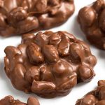 Chocolate Peanut Clusters on parchment paper