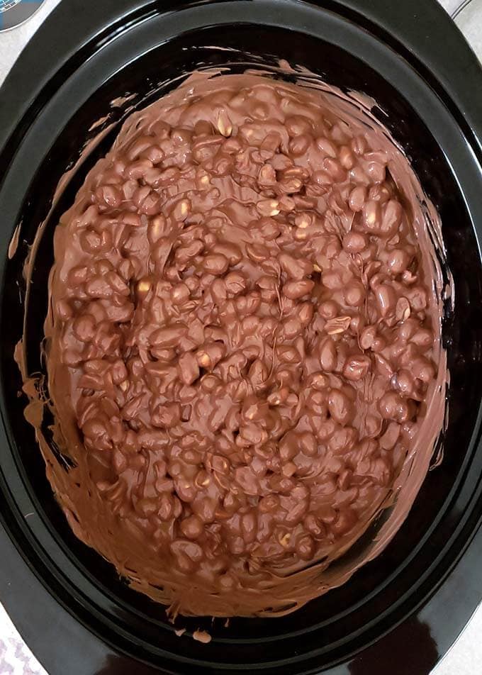 Slow cooker full of melting white and semi-sweet chocolate chips