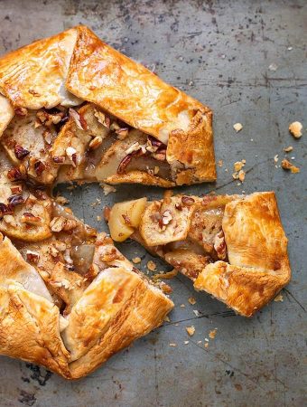 Apple Galette on a baking sheet with a slice slightly removed