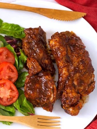 Two Country Style Ribs on a white plate with vegetables