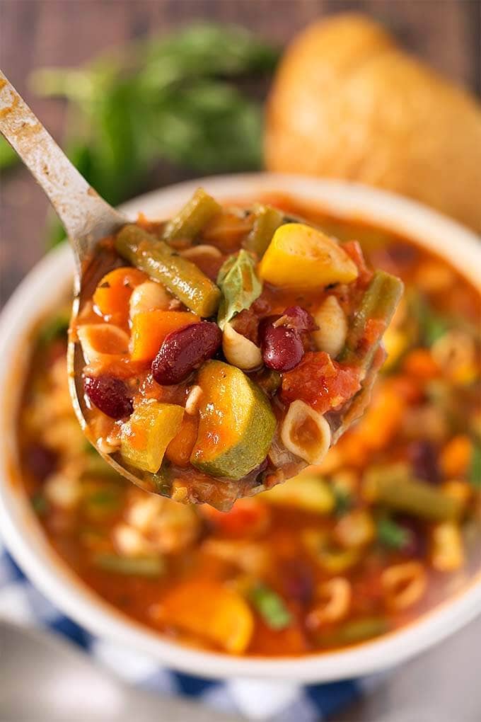 Closeup of a spoonful of Minestrone Soup in a white bowl