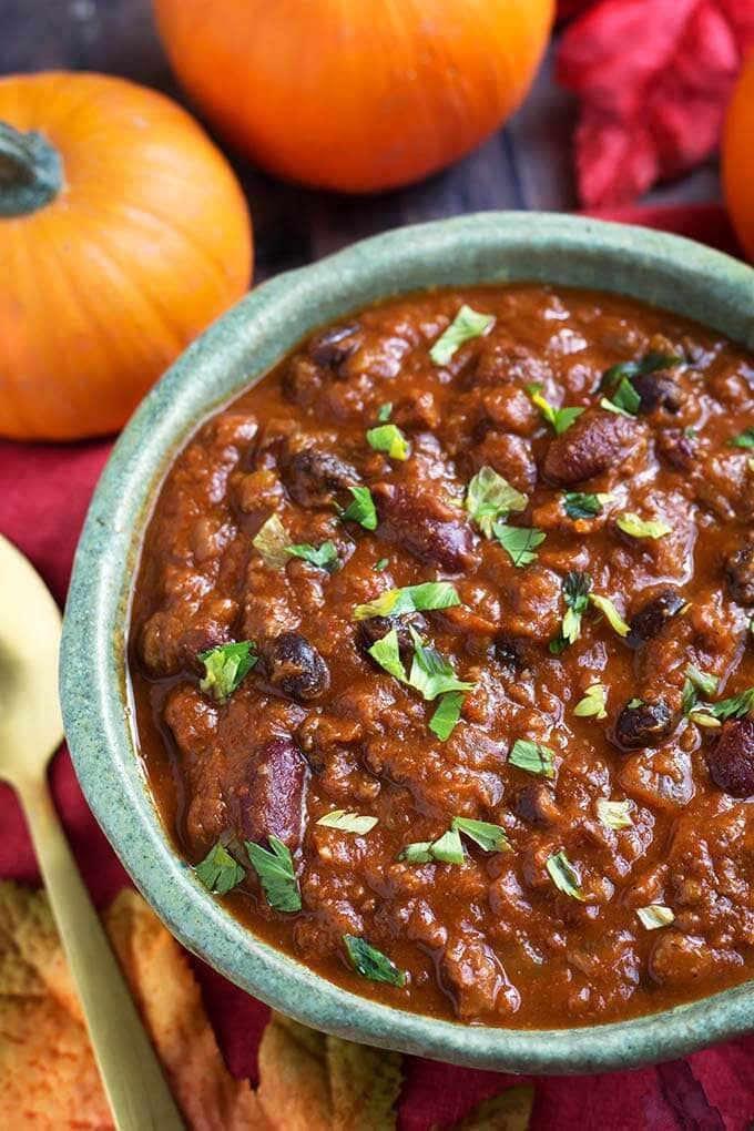 Pumpkin Chili in a turquoise bowl in front of two small pumpkins