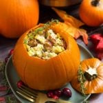 Stuffed pumpkin on a gray plate in front of fall leaves and a small pumpkin