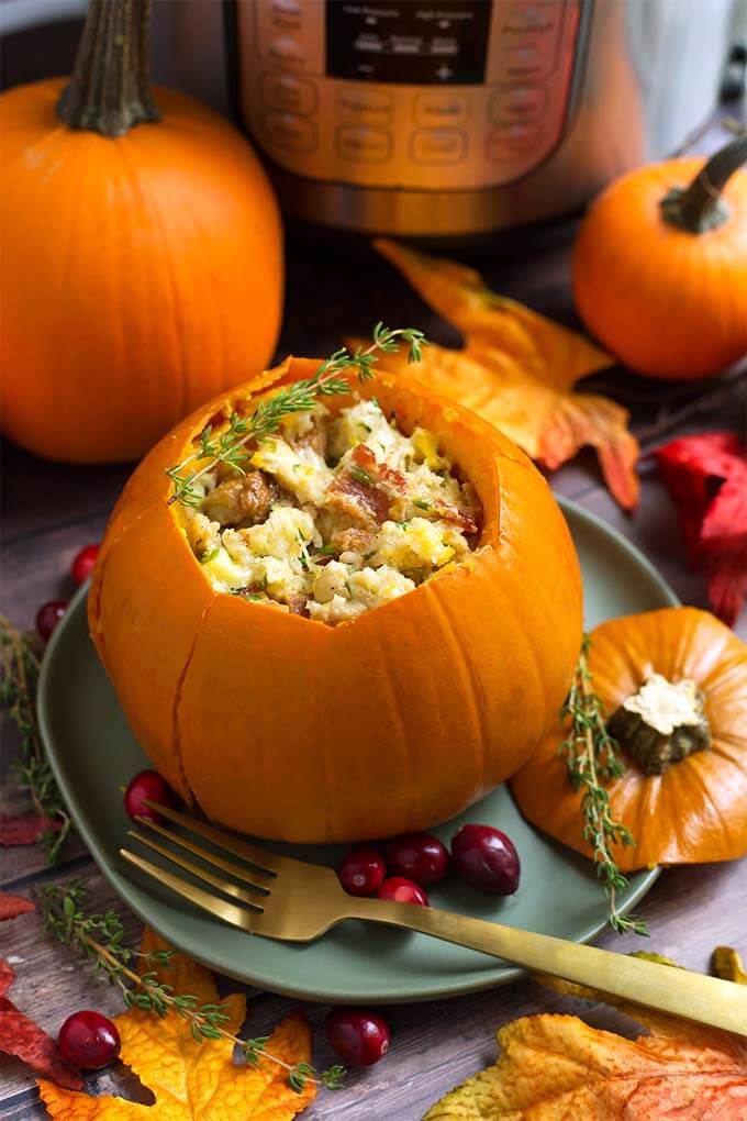 Stuffed pumpkin on a gray plate in front of fall leaves and a small pumpkin