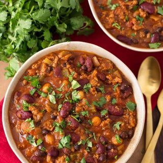 My Slow Cooker Turkey Chili Recipe has been a yummy staple in our home for over 10 years. Ground turkey, beans, a few veggies, and spices all loaded into the slow cooker to make the best healthy turkey chili recipe! Crock pot turkey chili is a delicious one-pot meal, and feeds a crowd! slow cooker chili by simplyhappyfoodie.com #slowcookerturkeychili #crockpotturkeychili