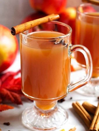 Spiced Apple Hot Toddy in a glass with a handle topped with a cinnamon stick and anise seed