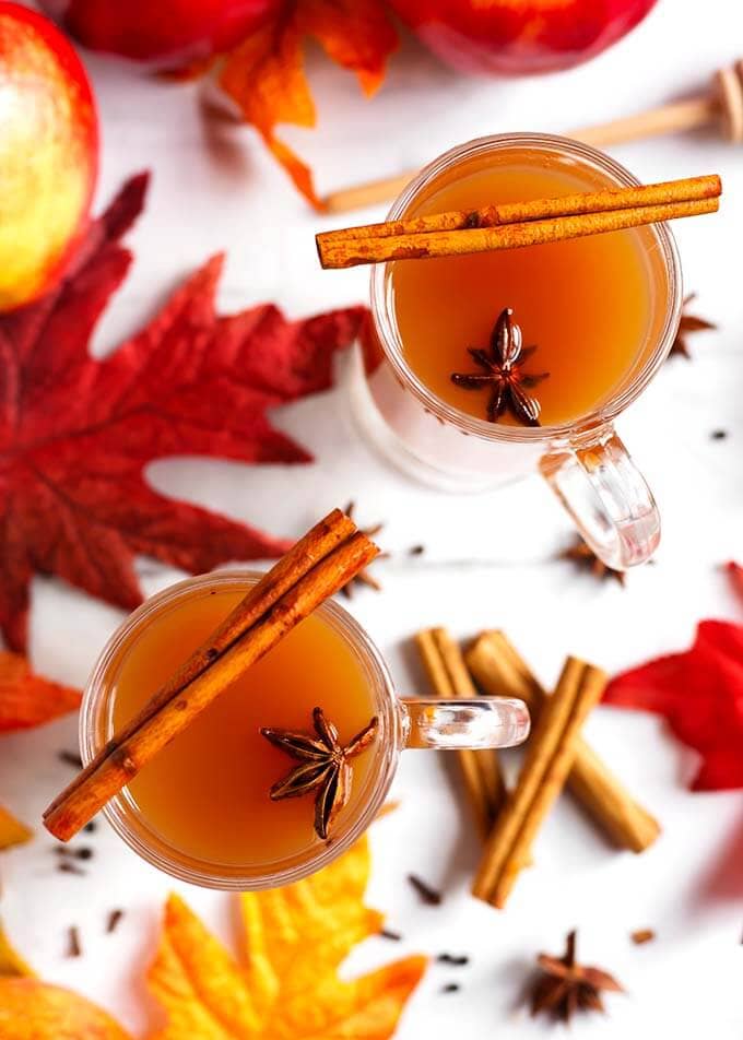 Top view of two Spiced Apple Hot Toddy in glasses topped with cinnamon sticks and whole anise