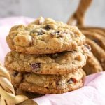 Closeup of three Cranberry Dark Chocolate Cookies stacked on a basket lined with a pink napkin
