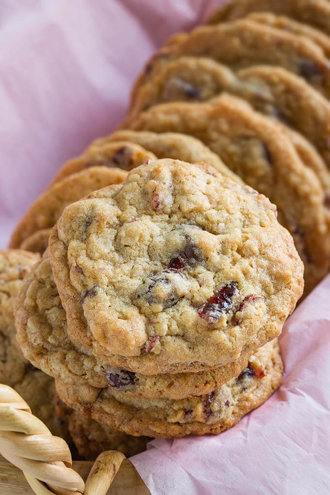 Several Cranberry Dark Chocolate Cookies on a pink napkin in a oblong basket