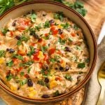 Creamy Chicken Chili in a beige bowl on a wooden board