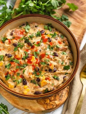 Creamy Chicken Chili in a beige bowl on a wooden board