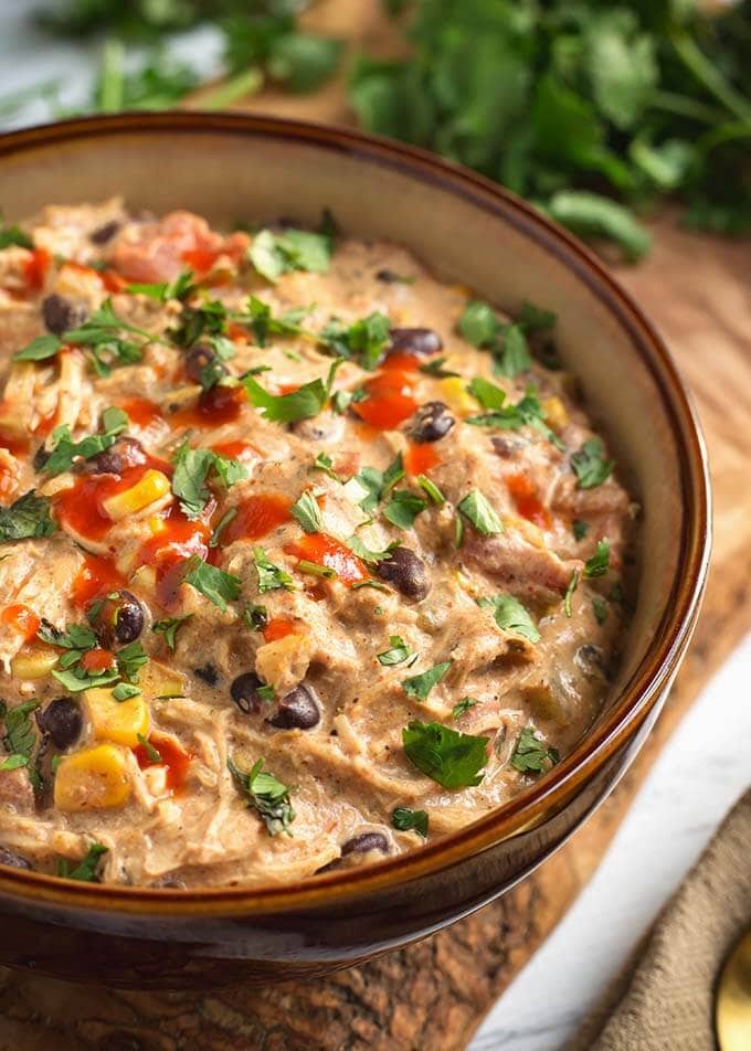 Creamy Chicken Chili in a beige bowl on a wooden board