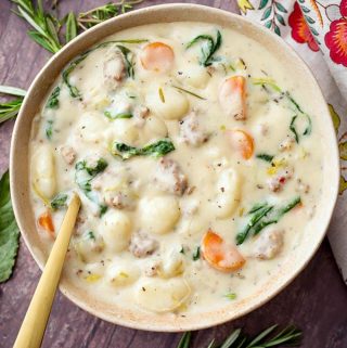 This Slow Cooker Creamy Sausage Gnocchi Soup recipe is a delicious, rich comfort food. What's better than a comforting bowl of hearty soup? This crock pot sausage gnocchi soup is amazing! Serve it with fluffy dinner rolls and you will have a wonderful and satisfying meal! simplyhappyfoodie.com #slowcookersausagegnocchisoup #crockpotsausagegnocchisoup