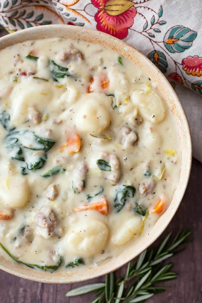 Closeup of Creamy Sausage Gnocchi Soup in a beige bowl