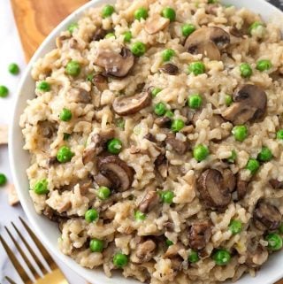 Instant Pot Mushroom Risotto with Peas is creamy, delicious, and super easy to make. This risotto is good with or without the peas. If you don't like them, just leave them out. Pressure cooker mushroom risotto with peas is one of my favorite Instant Pot recipes! simplyhappyfoodie.com #instantpotrisotto #pressurecookerrisotto