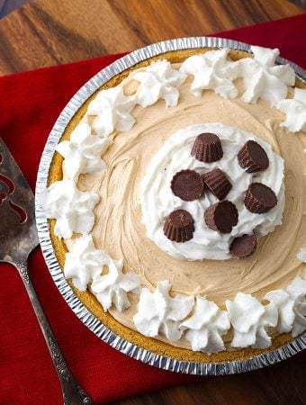 No Bake Peanut Butter Pie topped with whipped cream and chocolate candies has only 5 ingredients, but it tastes like you worked all day to make it! A sweet and creamy pie with delicious flavor that will satisfy the peanut butter lovers out there! This tasty peanut butter pie is perfect for a potluck, a party, or for any time you want an easy and yummy dessert! dessert recipes by simply happy foodie #nobakepie #nobakepeanutbutterpie