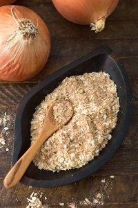 Homemade Onion Soup Mix in a dark wooden leaf-shaped bowl with a wooden spoon