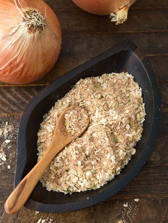 Homemade Onion Soup Mix in a dark wooden leaf-shaped bowl with a wooden spoon