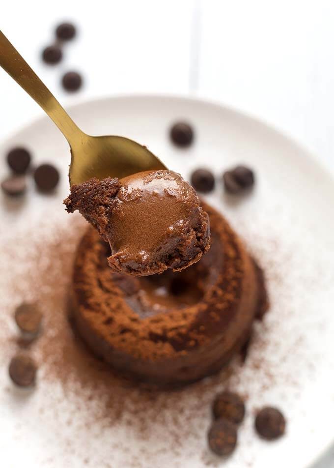 Closeup of spoonful of Chocolate Lava Cake over a white plate