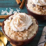 Rice Pudding topped with whipped cream in a brown bowl