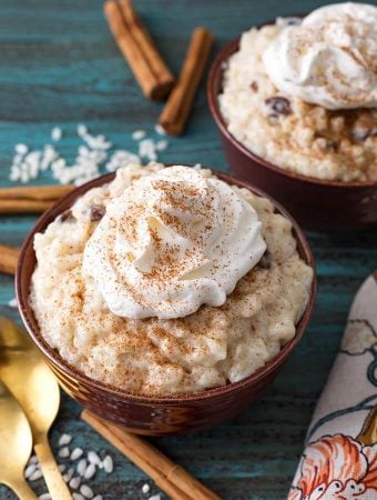 Rice Pudding topped with whipped cream in a brown bowl