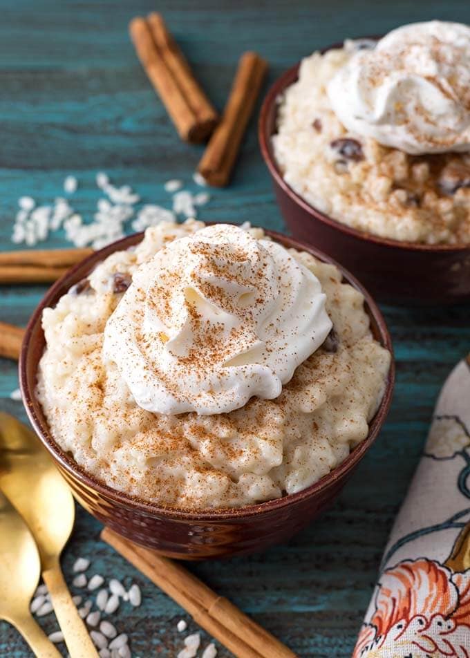 Rice Pudding topped with whipped cream in a brown bowl