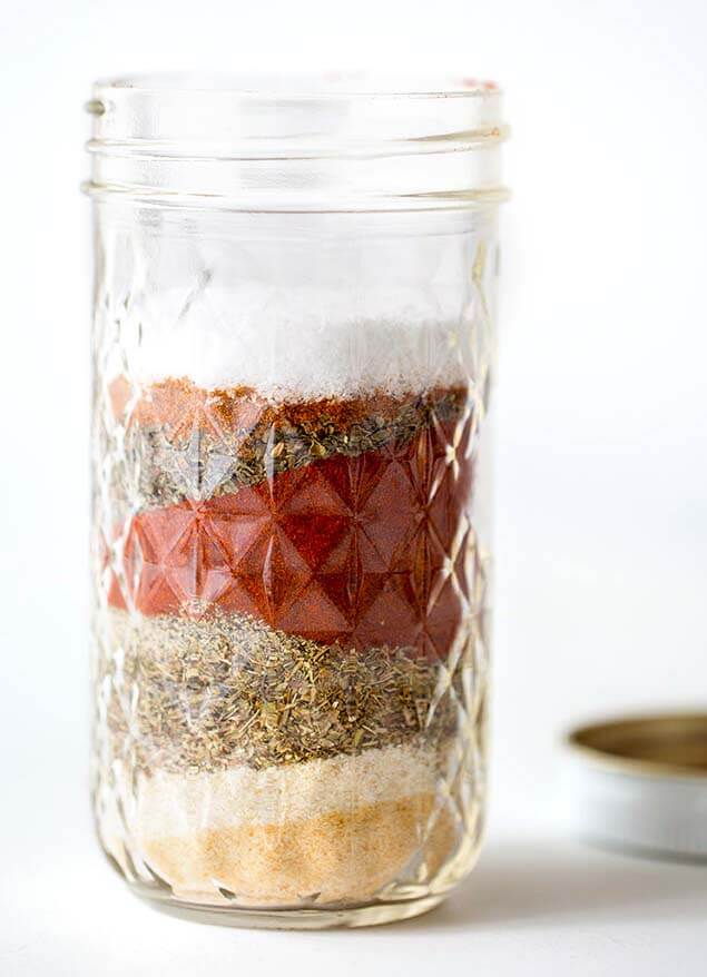 Small canning jar with layered Homemade Cajun Spice Blend