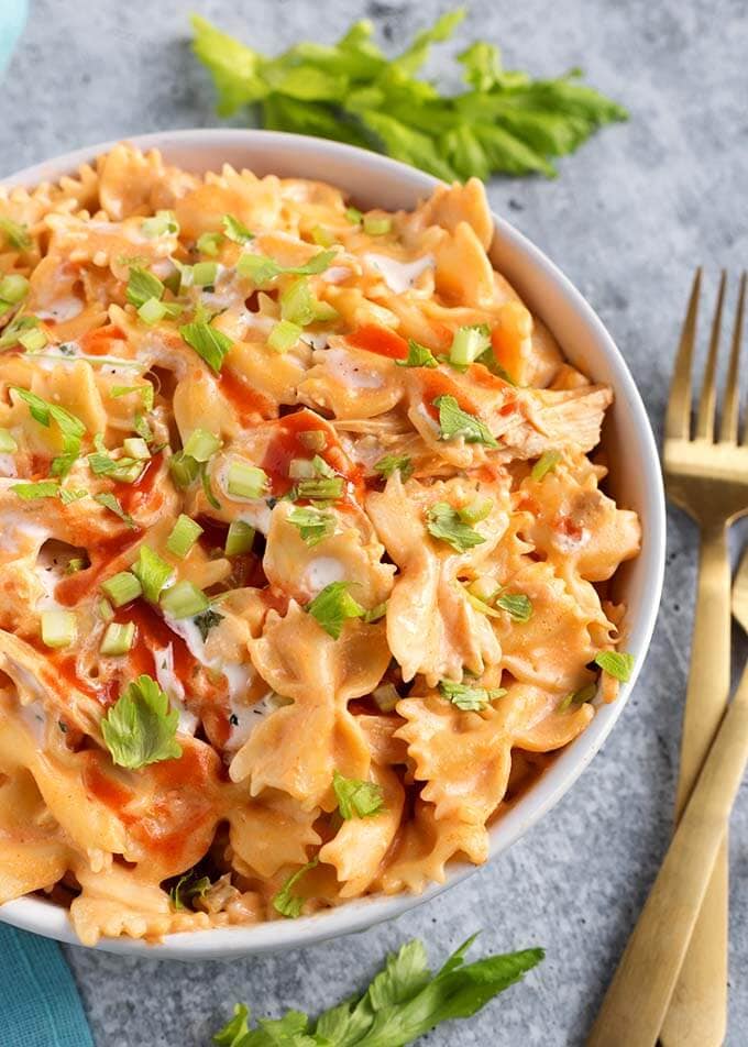 Buffalo Chicken Pasta in a white bowl next to two gold forks