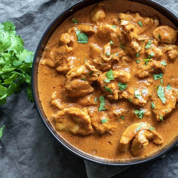 Low Carb Butter Chicken in a black bolw on top of a gray napkin