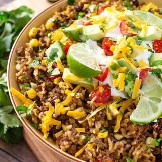Instant Pot Beef Taco Bowls are an easy to make Instant Pot dump and start recipe. Delicious taco flavor, ground beef, beans, corn, and rice make this a one-pot meal. This pressure cooker beef taco bowl is perfect for meal prep, and is a healthy lunch or dinner. simplyhappyfoodie.com #instantpottacobowl #instantpotbeeftacobowl #pressurecookertacobowl