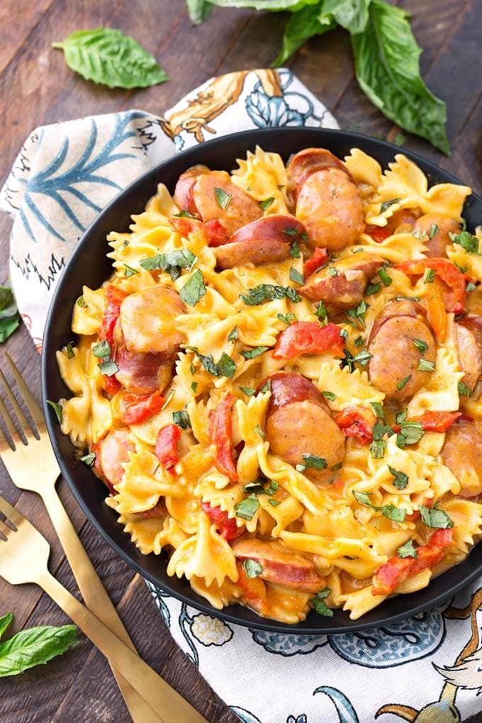 Cajun Pasta on a black plate next to two gold forks