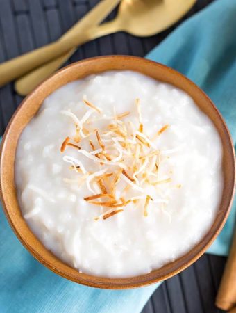 Coconut Rice Pudding in a brown bowl topped with toasted coconut