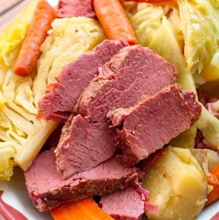 Corned Beef and Cabbage on a white plate with red boarder