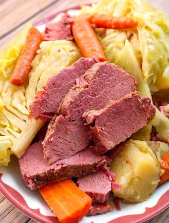 Corned Beef and Cabbage on a white plate with red boarder