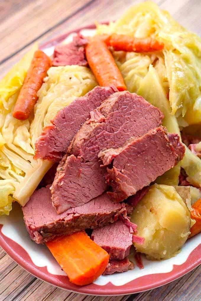 Corned Beef and Cabbage on a white plate with red boarder