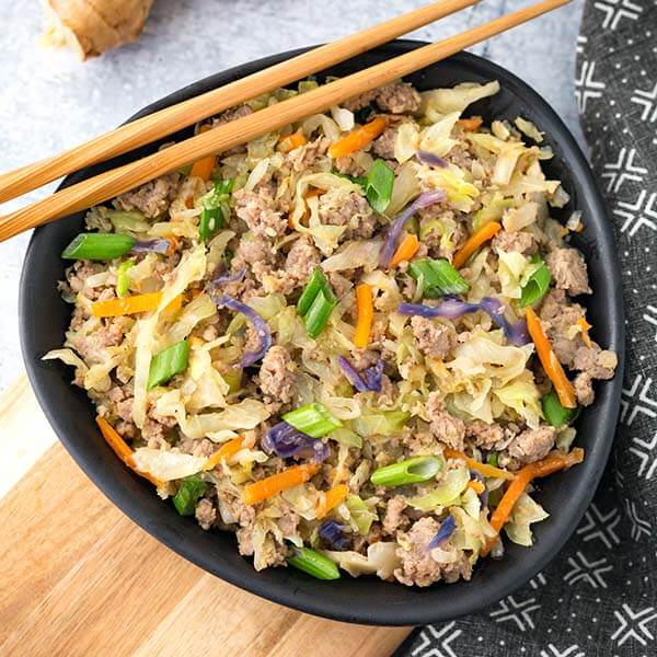 egg roll in a bowl in a black bowl with bamboo chopsticks