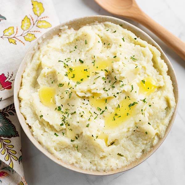 top view of a mashed cauliflower in a beige bowl