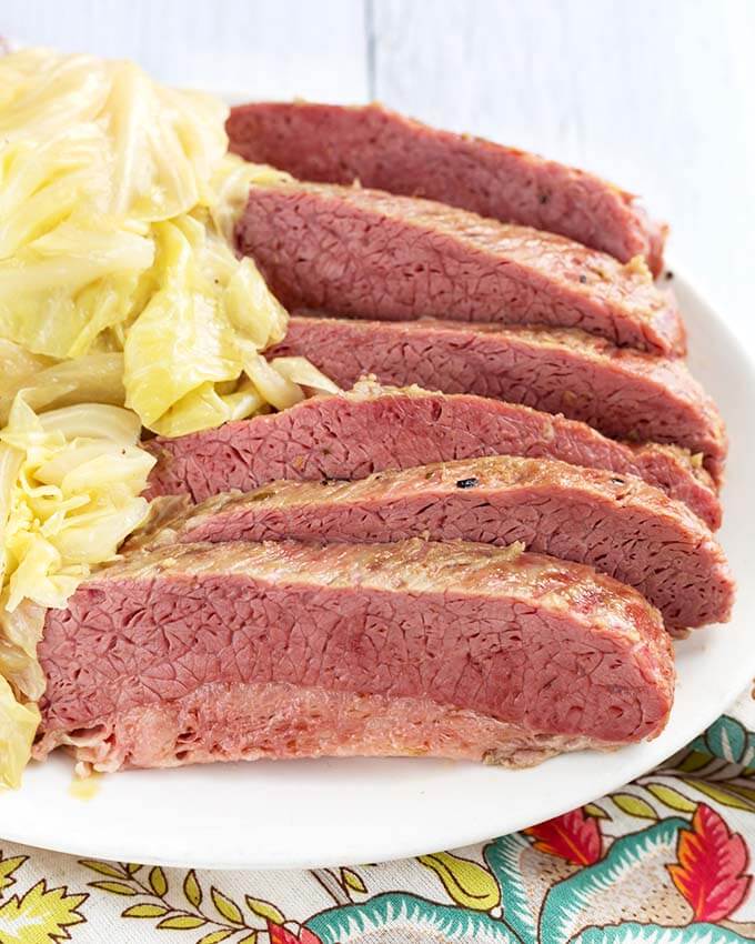 Close up of Sliced Corned Beef and Cabbage on a white plate