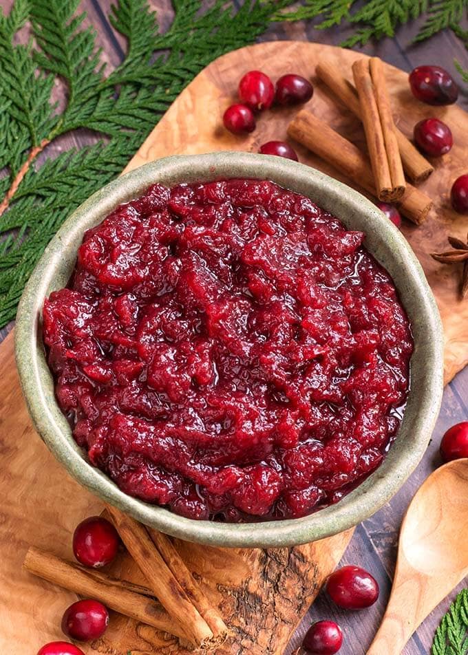 Cranberry Sauce in a green bowl with greenery around