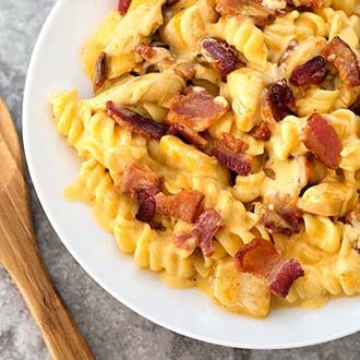 Instant Pot Chicken Bacon Ranch Pasta on a white plate next to wooden spoon