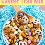 Bunny Bait Easter Trail Mix in a bowl with spoon on blue easter grass.