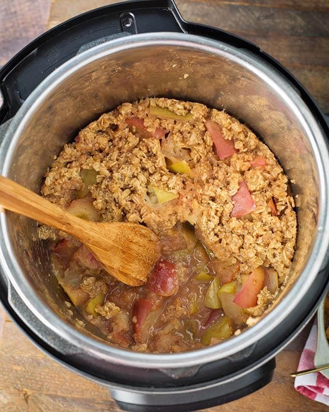 Apple Crisp with wooden mixing spoon in pressure cooker pot