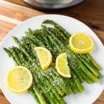 Asparagus on a white plate with lemon slices
