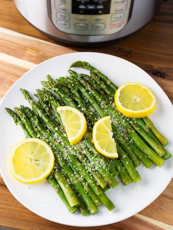 Asparagus on a white plate with lemon slices