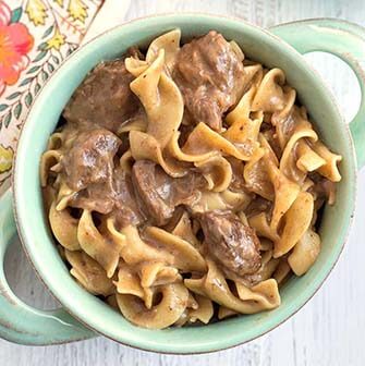 beef and noodles in a turquoise bowl with handles