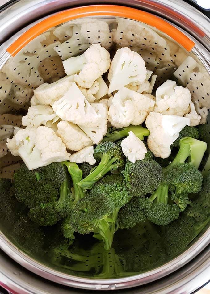 Broccoli Cauliflower in steamer basket in pressure cooker