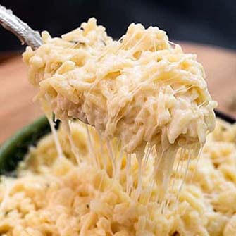 silver spoon serving cheesy garlic orzo